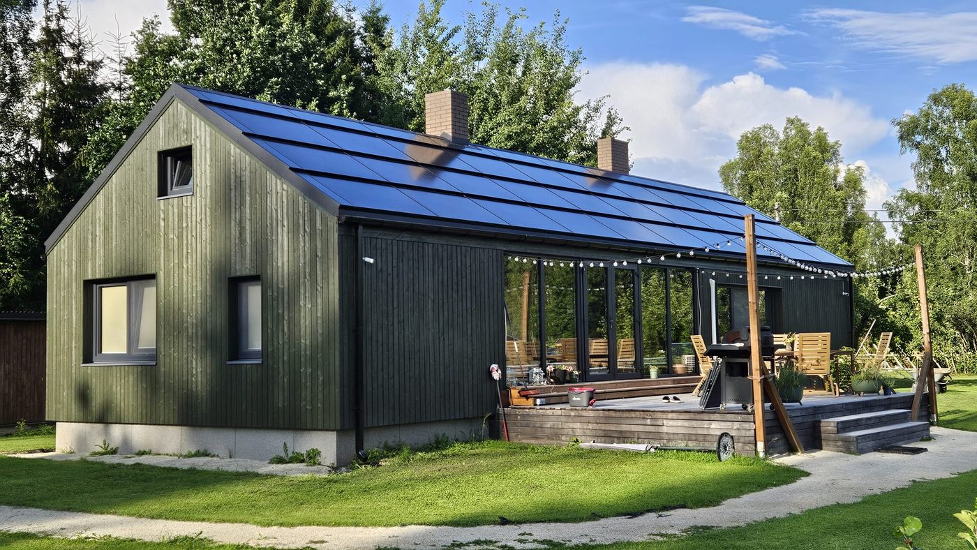 Timber-clad home with integrated solar roof and deck
